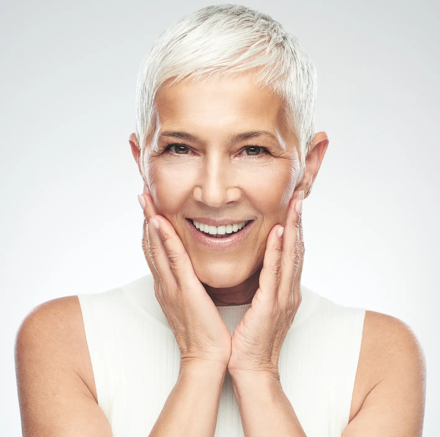 Senior woman posing in front of gray background. Skin Rejuvenation in St. Louis, MO